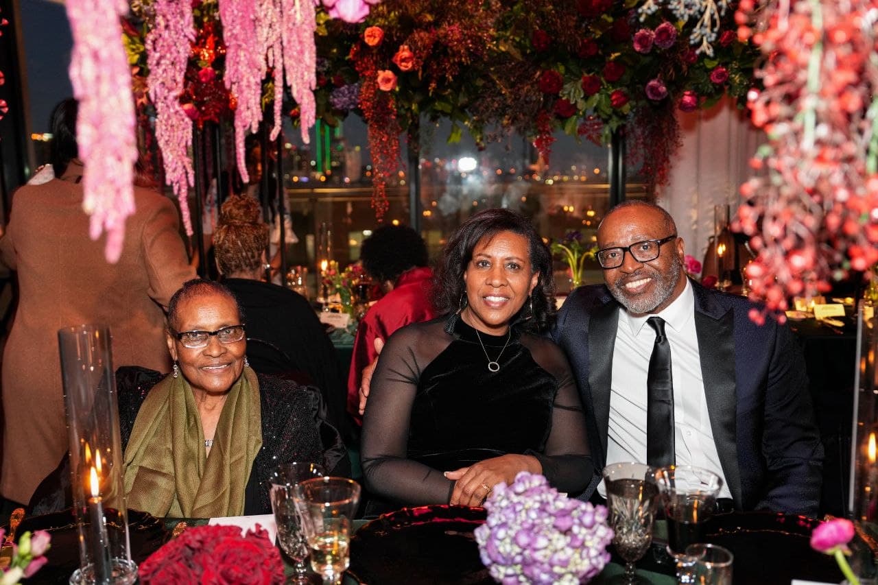 Guests under hanging floral installation with Dallas skyline views